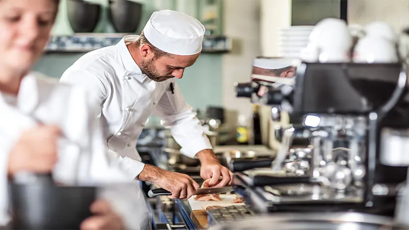 Chef preparing food in kitchen.