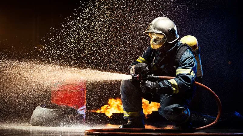  A fireman fights with fire using water extinguisher 