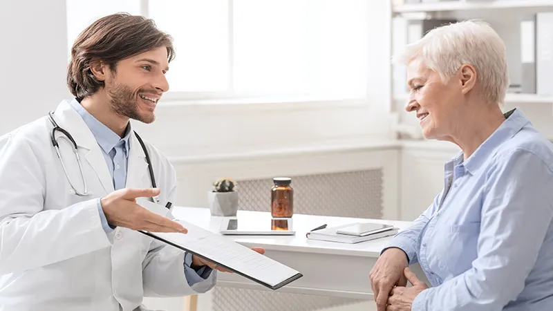 Cheerful doctor explaining treatment plan to a senior female patient