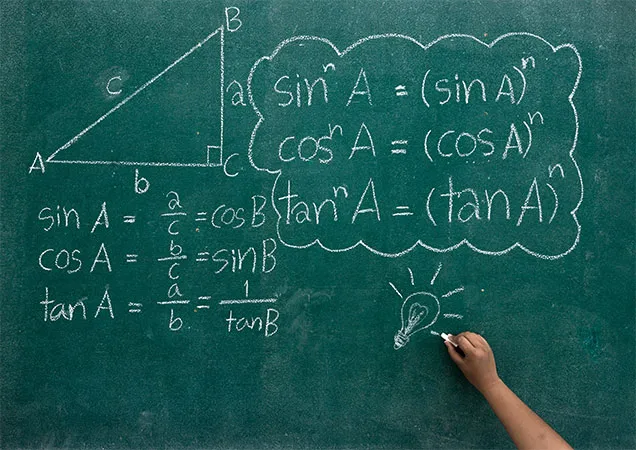 Students writes the mathematics formulas on a blackboard with bulb sign