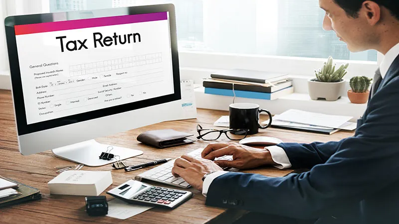 A tax accountant works on tax return document