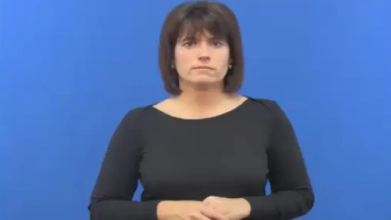 Short haired woman instructor in a room with a blue background, standing still