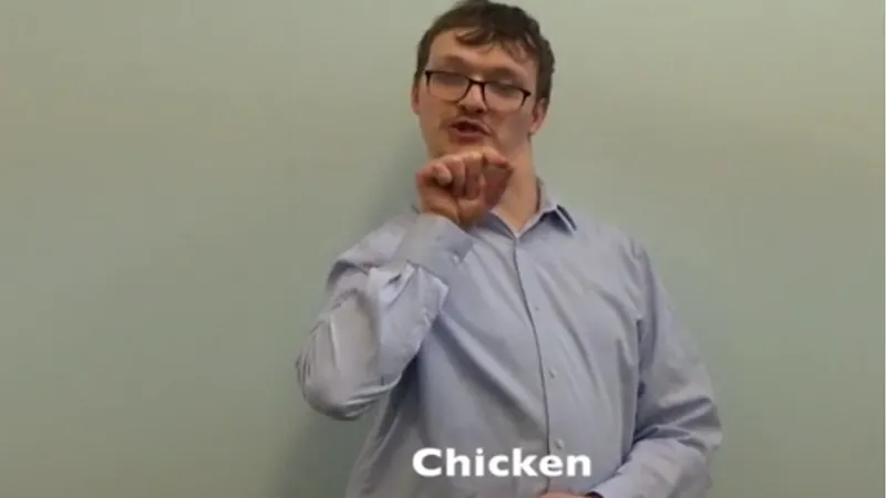 BSL interpreter signing Chicken in British sign language UK