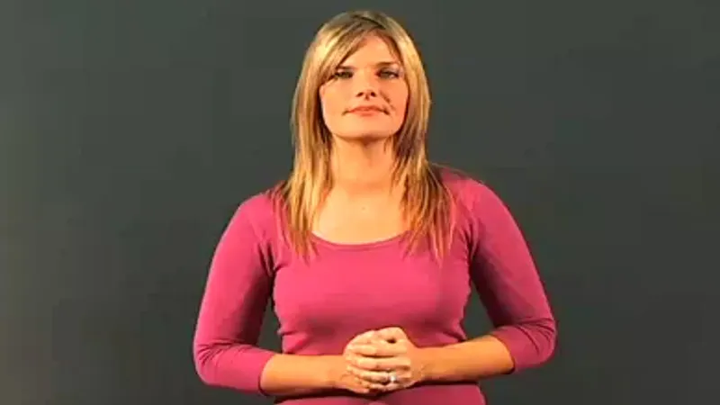 A BSL interpreter standing in a normal posture 