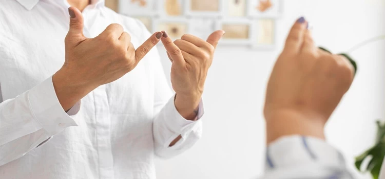 Man wearing white shirt signing in British Sign Language