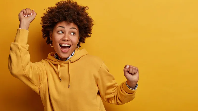 A happy girl wearing a yellow hoodie 