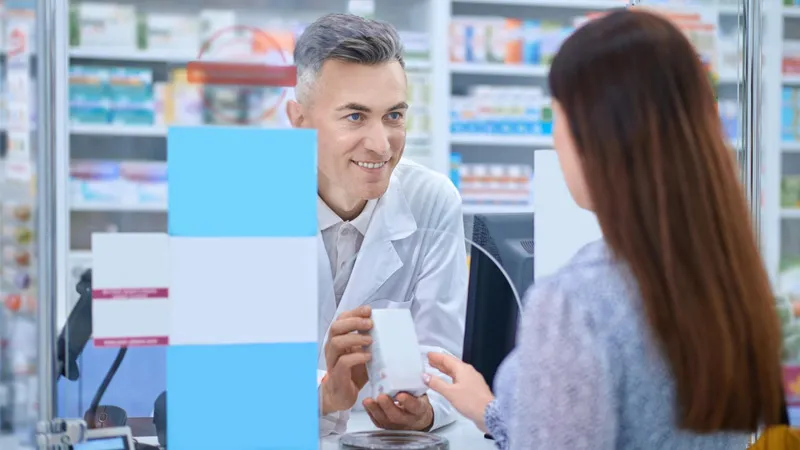A pharmacist showing a product to a female customer