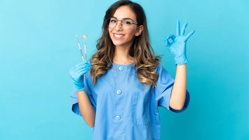 Young female dentist in her scrubs with equipments