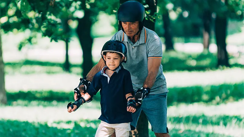 A father teaching his son to skates on roller skates