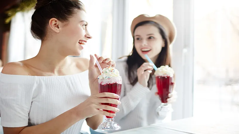 Two happy women enjoying their cocktails