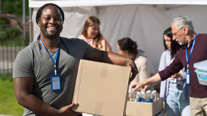 A photo of a social worker with a box of food supplies