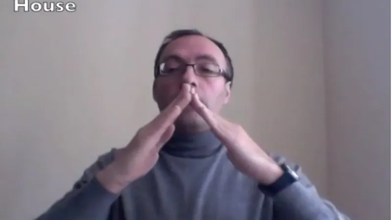 BSL interpreter signing House in British sign language
