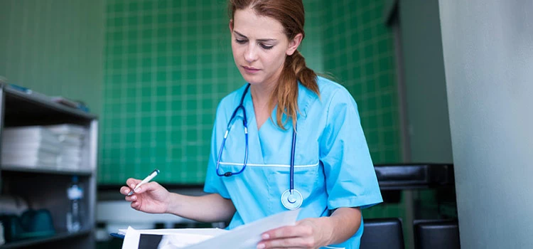 A nurse taking notes on patient’s health at the hospital
