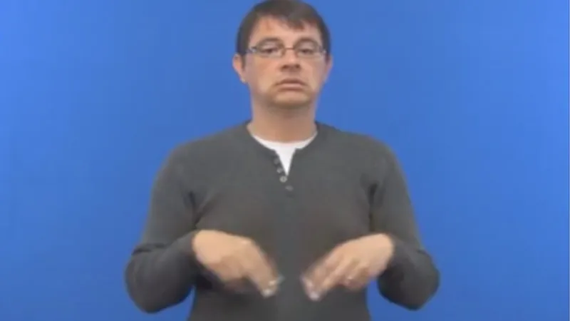A man shows how to sign “dance” in British Sign Language 