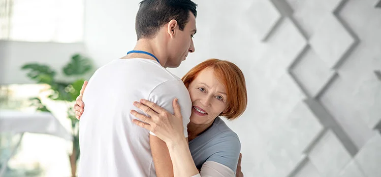  Elderly patient expressing her gratitude by hugging her therapist.