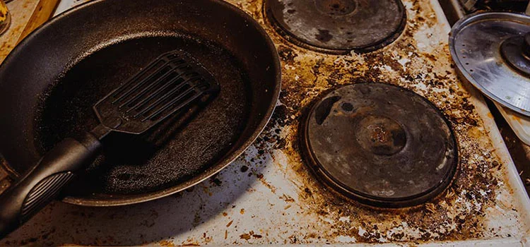 Junked pan left on top of a dirty stove for a long time