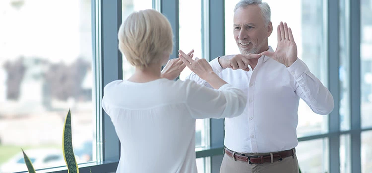 Two individuals communicating in British sign language