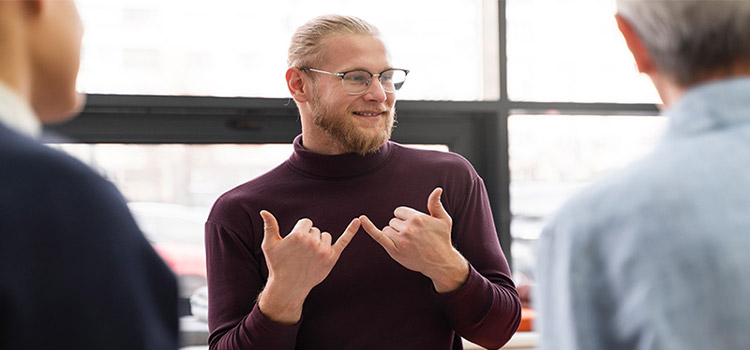 Portrait of young man teaching sign language.