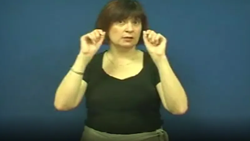 BSL tutor with both fist raised