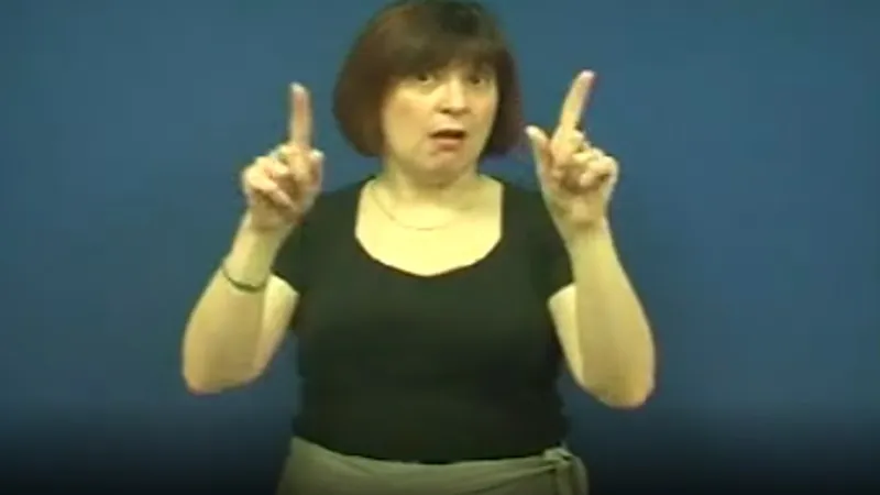 BSL teacher with index finger of both the hands raised