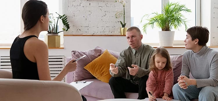  Parents, along with their little girl, having a therapy session with a psychologist.