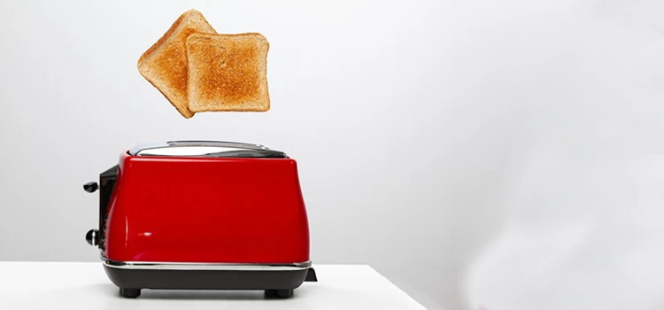 Two toasts jumping out of a red toaster