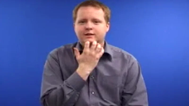 A man demonstrate how to sign “Green” in British Sign Language