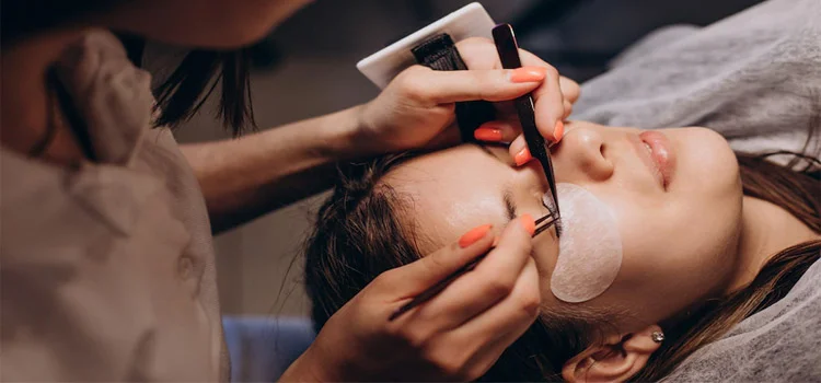  Lash technician performing eyelash extension procedure on her client