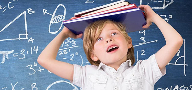 Cute little boy holding books above his head with a screen with mathematical formulas behind him.