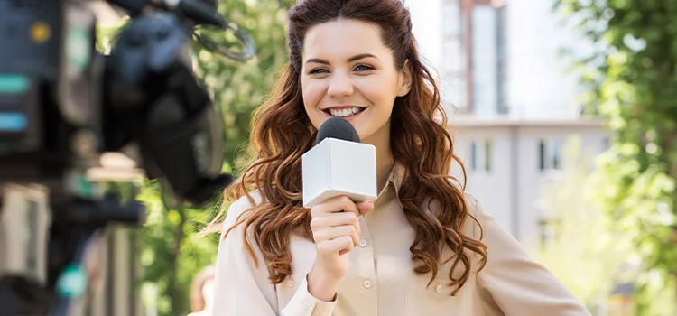 A smiling female journalist with her microphone in the middle of a live TV report