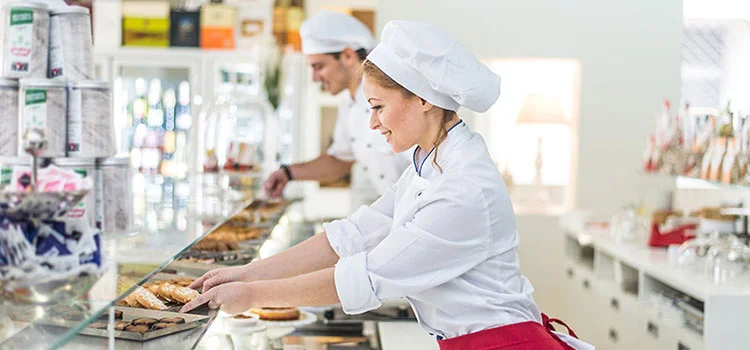 Pastry sellers are placing sweets on the shop counter