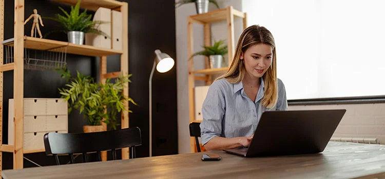 A female student attending an online class or exam on a laptop in a quiet location