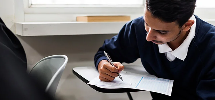 A student attentively filling out a multiple-choice question form in an exam hall 