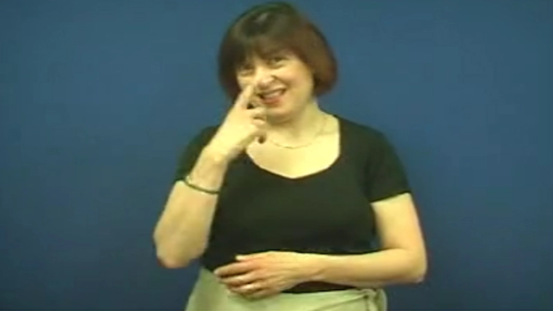 Woman shows how to sign “Can” in British Sign Language
