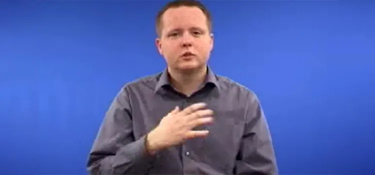 A man shows how to sign “frog” in British Sign Language with hand posture