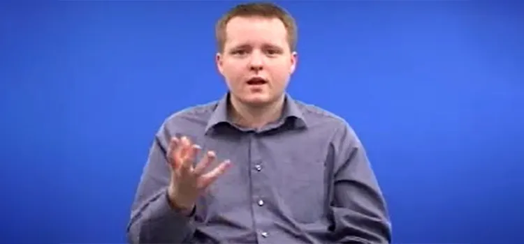 A British Sign Language tutor with one hand raised