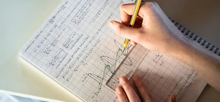 A student solving maths problem in notebook