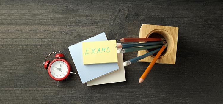 An image of pencils, clock and sticky notes displaying the concept of exam