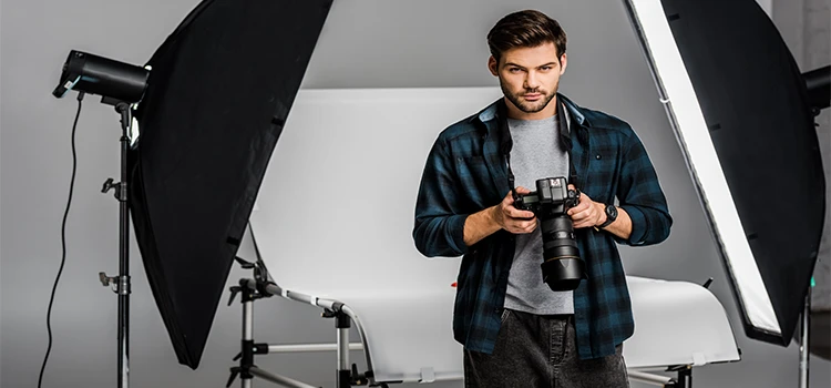 Young photographer using camera in photo studio
