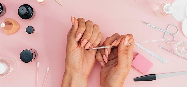 A self-taught nail artist grooming her nails with essential tools and polishes.