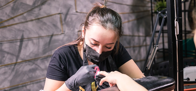 A nail technician applying nail polishes on her client's nails. 
