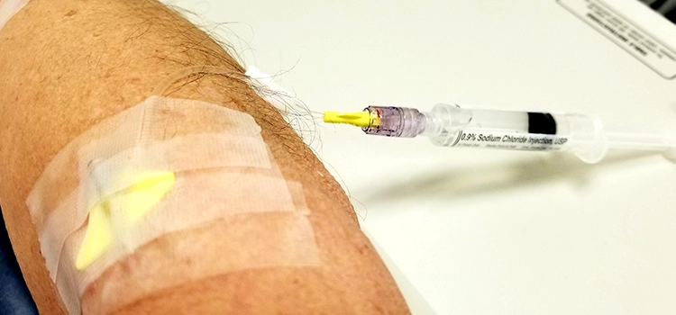 Doctors injecting medicine with a syringe through IO cannulation. 