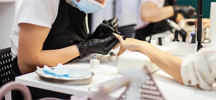 A manicurist polishing her client's nails gently while maintaining hygiene. 